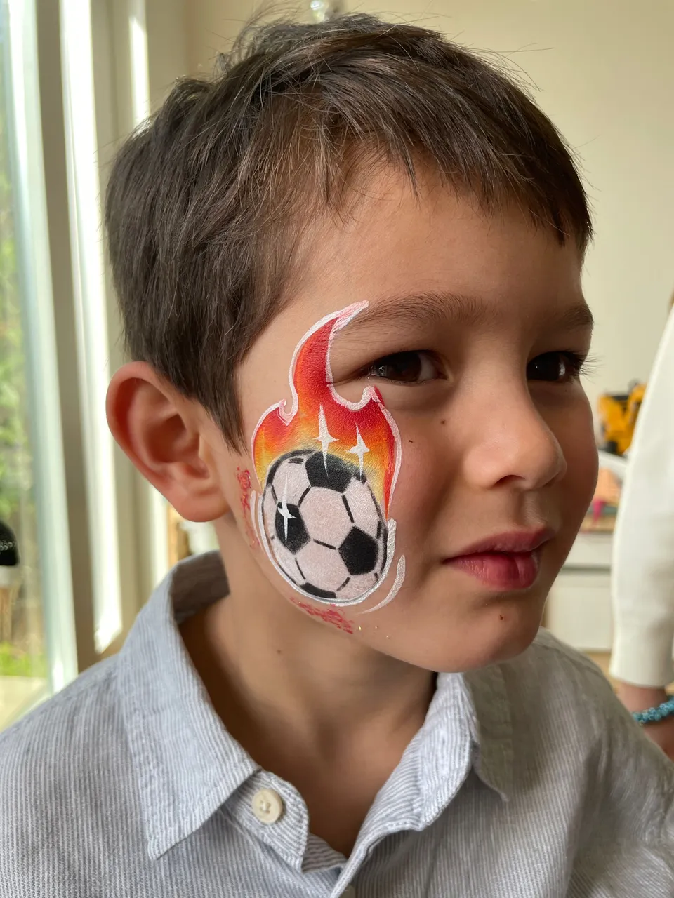 Ballon de football en flammes sur la joue d’un garçon