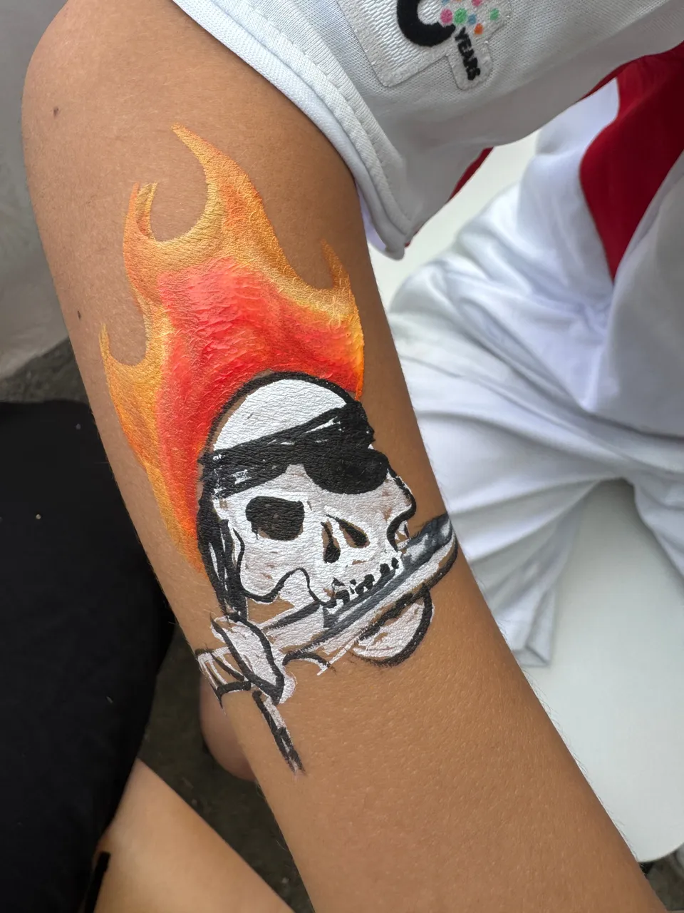 Tête de mort de pirate et flammes sur un avant-bras