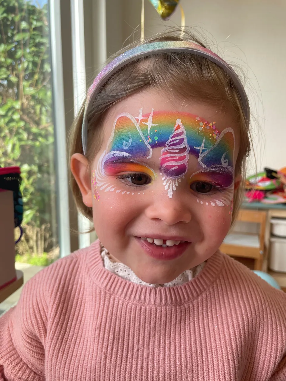Licorne arc-en-ciel sur le front d’une fillette